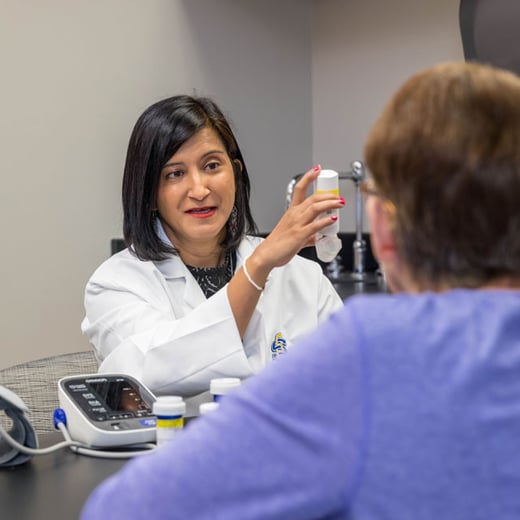 Professor Sharrel Pinto shows a client how to use an inhaler
