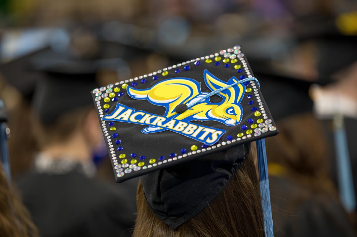 Student wearing mortar board with Jackrabbit on it.