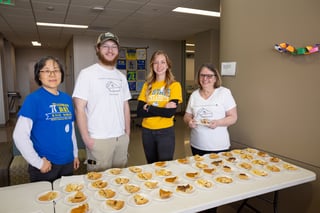 Students, faculty and staff with slices of pie