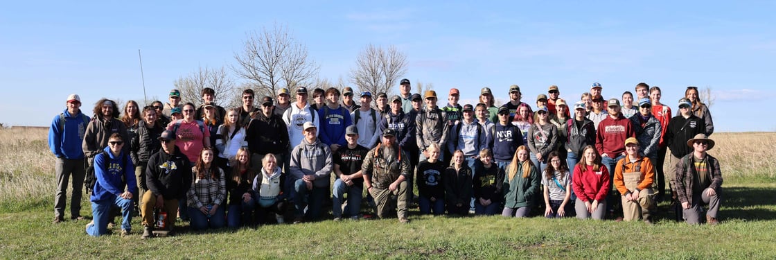 NRM230 Group photo: Students, faculty and graduate teaching assistants gathered outdoors in the Oak Lake Field Station.