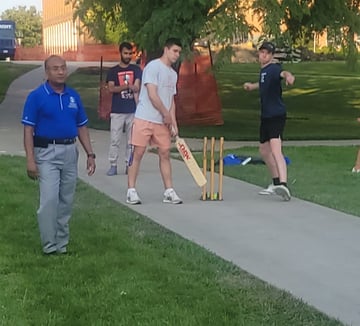 Dean Sanjeev Kumar watches campers play cricket,