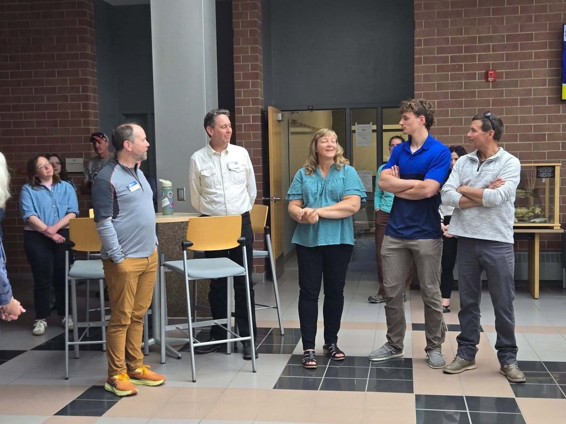 People standing and speaking in the Biostress Atrium during the UG graduation reception.