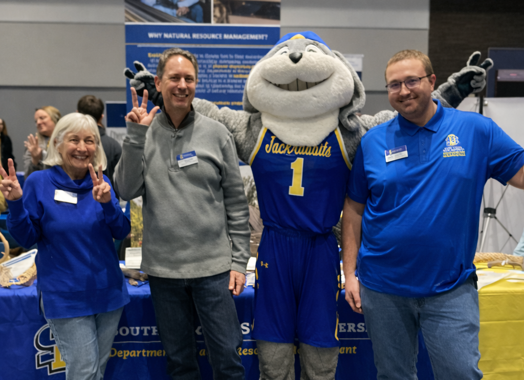 Staff pose with the Jackrabbits mascot at the NRM Junior Day booth. (from left) Michele Dudash, Josh Leffler, Jack (mascot), and Riley Mounsdon
