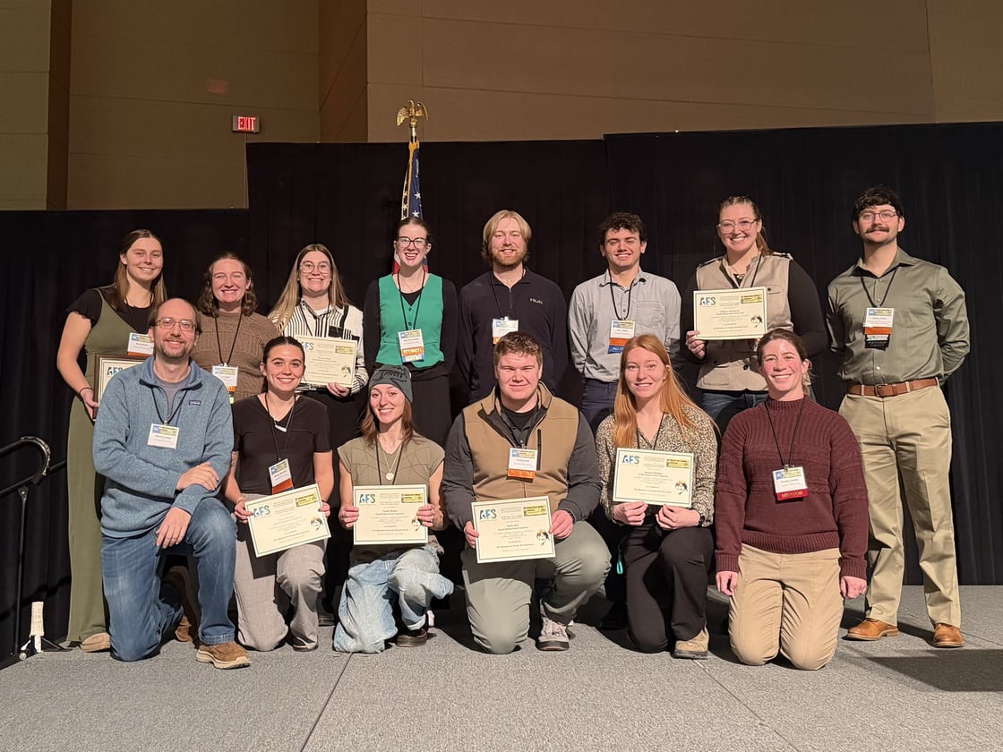 Conference attendees pose to the photo holding their award
