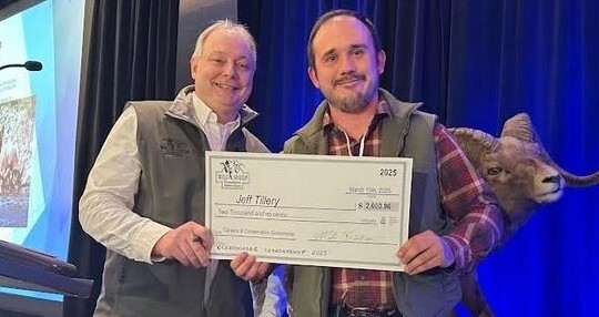 Jeff Tillery (right) poses with the donor, holding a large scholarship certificate check.