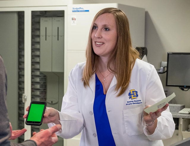 Assistant prof Erin Miller shows a client an cell phone app
