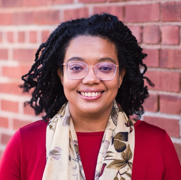 photo of Valeria Wicker smiling against a red brick background